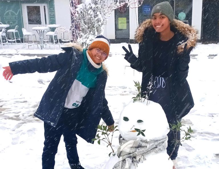 Enfants et un bonhomme de neige sur la place de l'Hôtel de Ville de Beuzeville