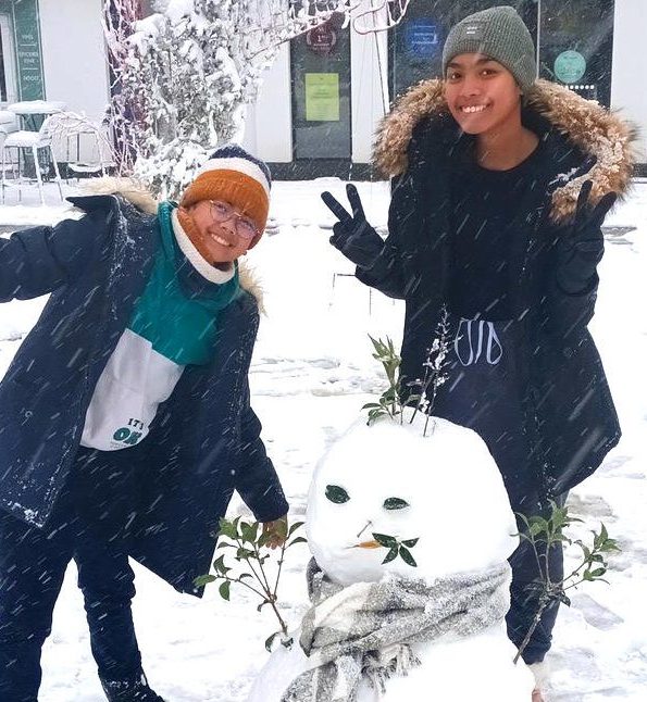Enfants et un bonhomme de neige sur la place de l'Hôtel de Ville de Beuzeville